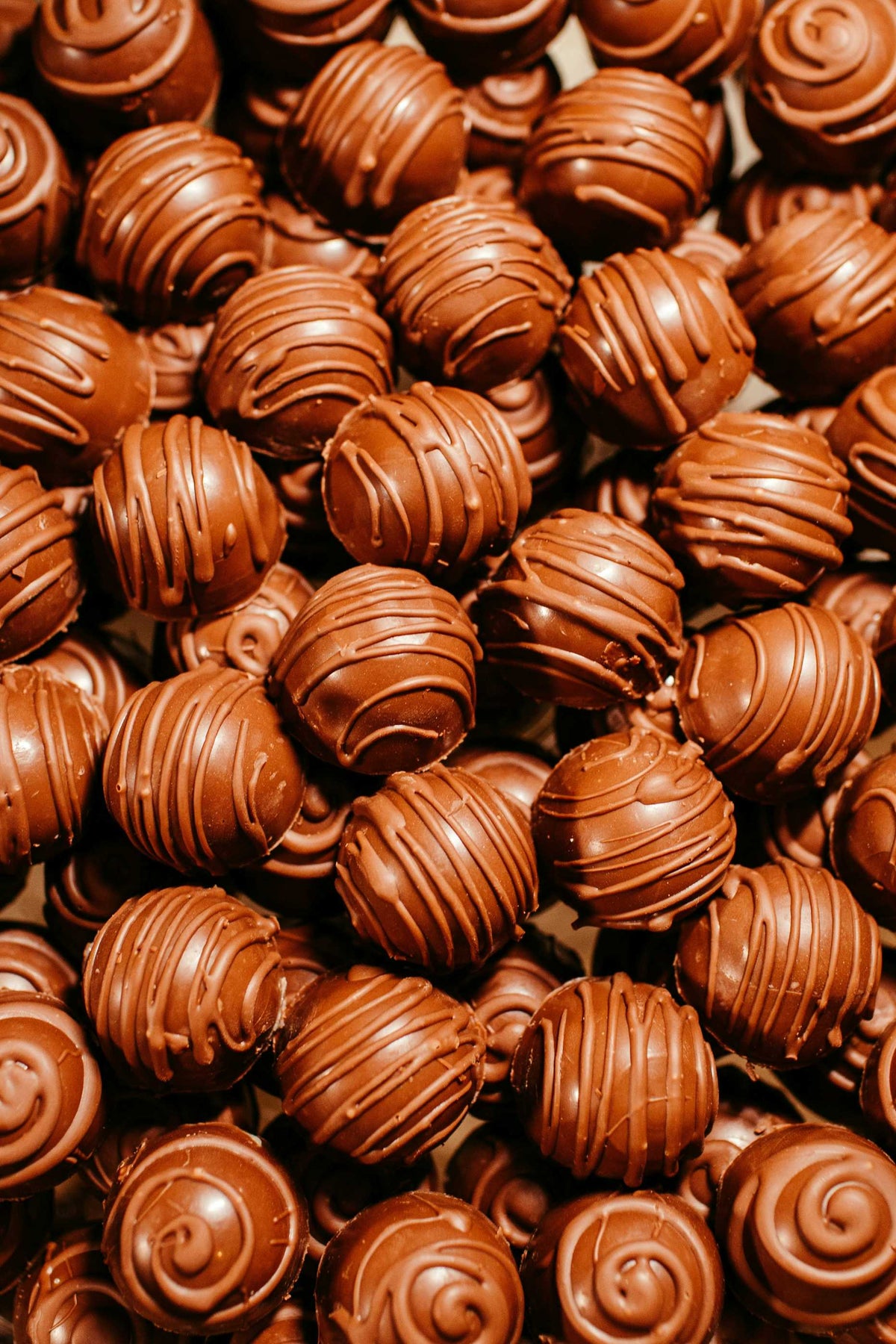 Duftnote Praline – Schokoladenpralinen mit Schokoladenstreifen dicht gehäuft