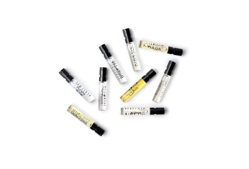 Kinetic Perfumes Discovery Set 11 × 2 ml – verstreute Probenfläschchen mit schwarzen Kappen auf Weiss