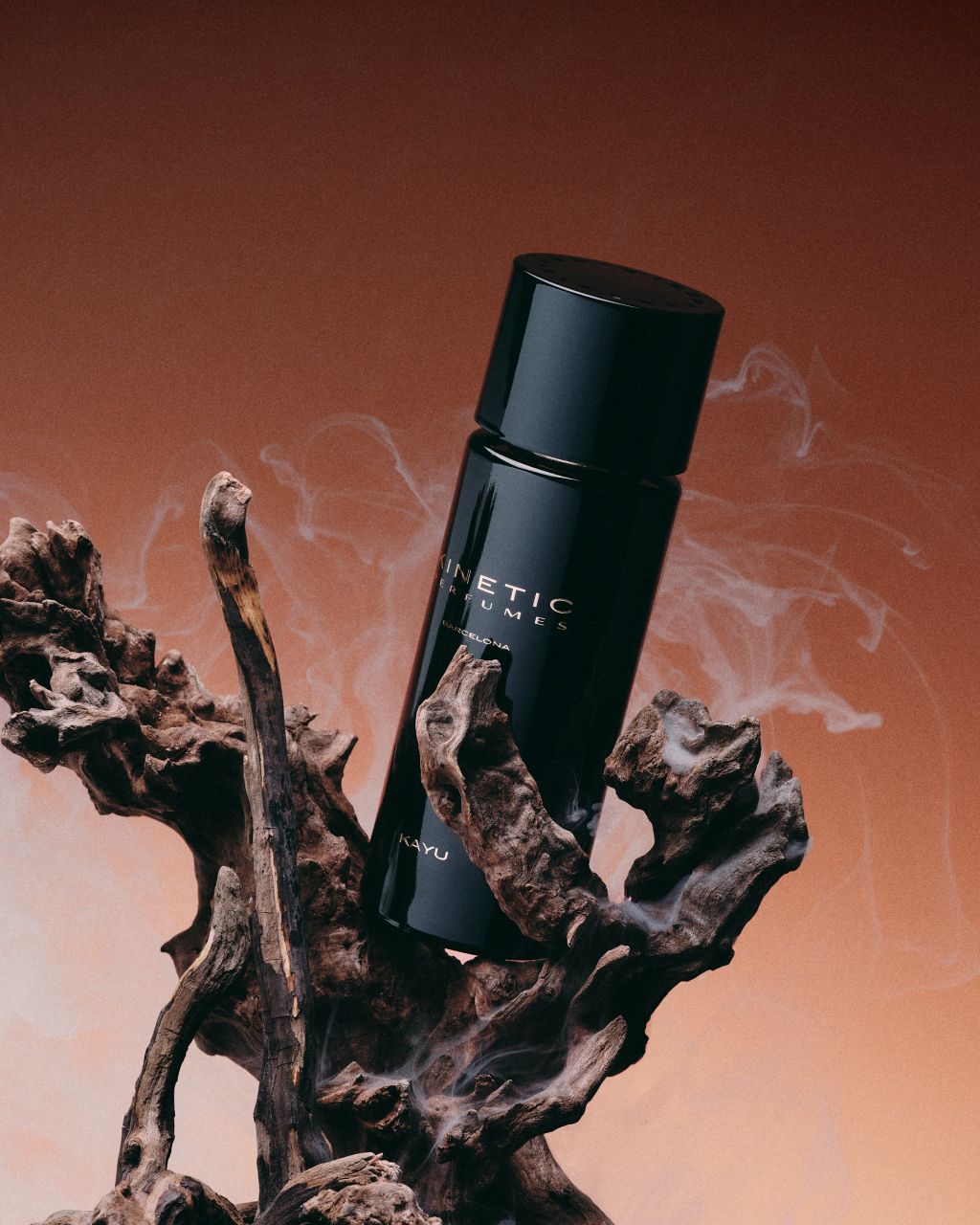 Kinetic Perfumes Kayu Extrait de Parfum 100 ml – schräger Flakon in Treibholz mit Rauch vor kupferrotem Verlauf