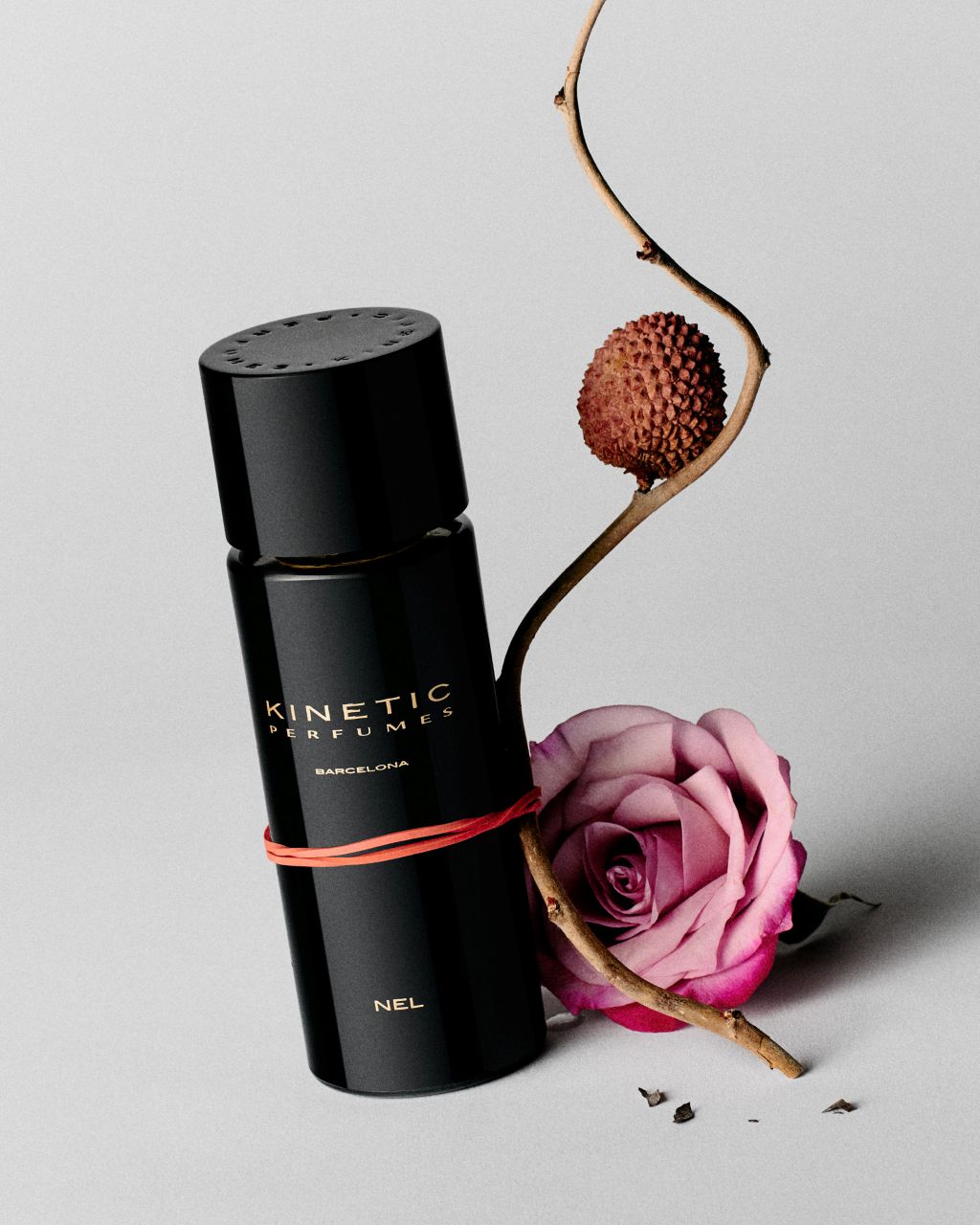 Kinetic Perfumes Nel Extrait de Parfum 100 ml – schwarzer Flakon mit rotem Band, rosa Rose und Litschi am Zweig
