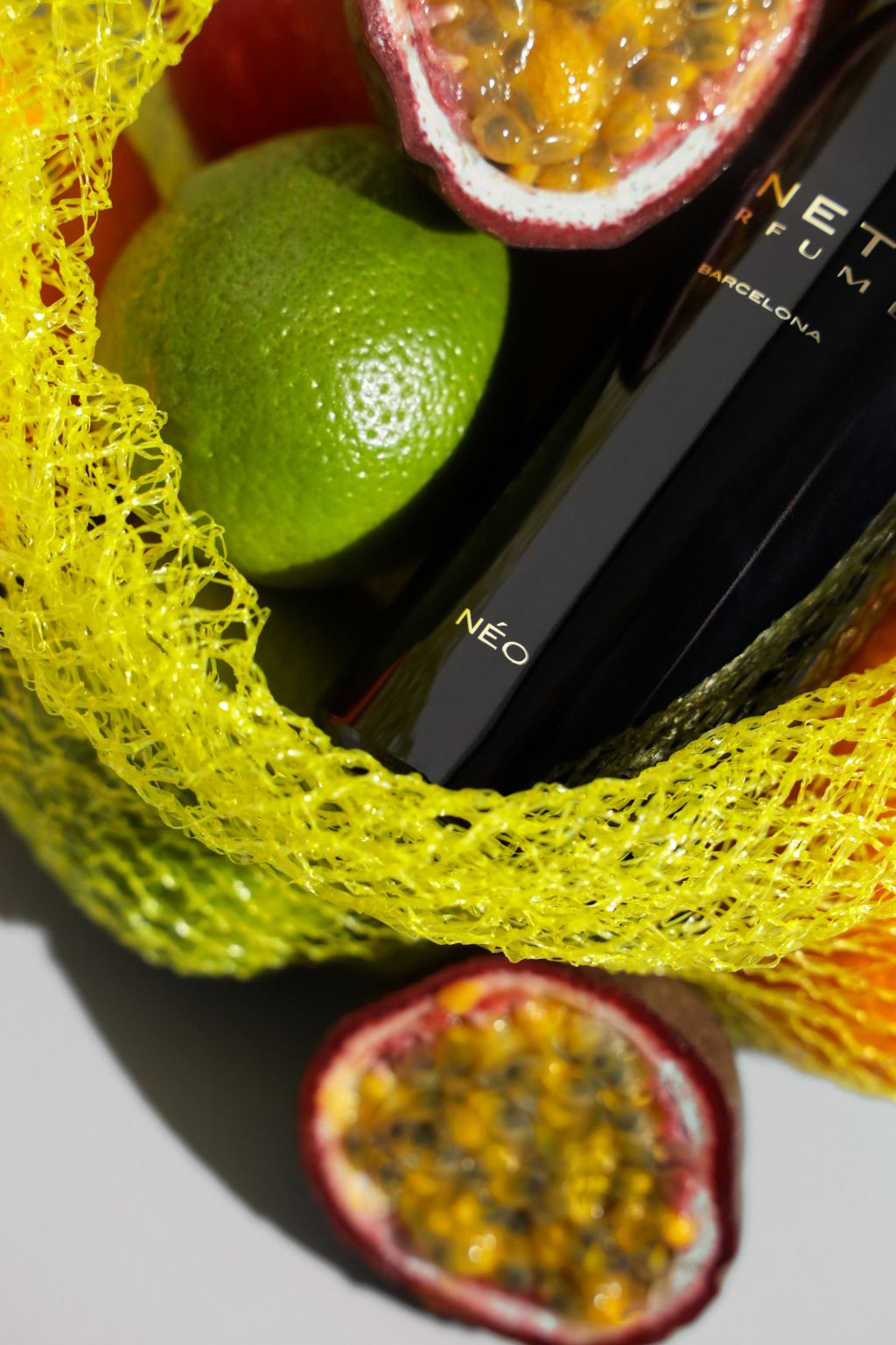 Kinetic Perfumes Néo Sillage Extrait de Parfum 100 ml – Nahaufnahme Flakon-Etikett im gelben Netz mit Limette und Maracuja