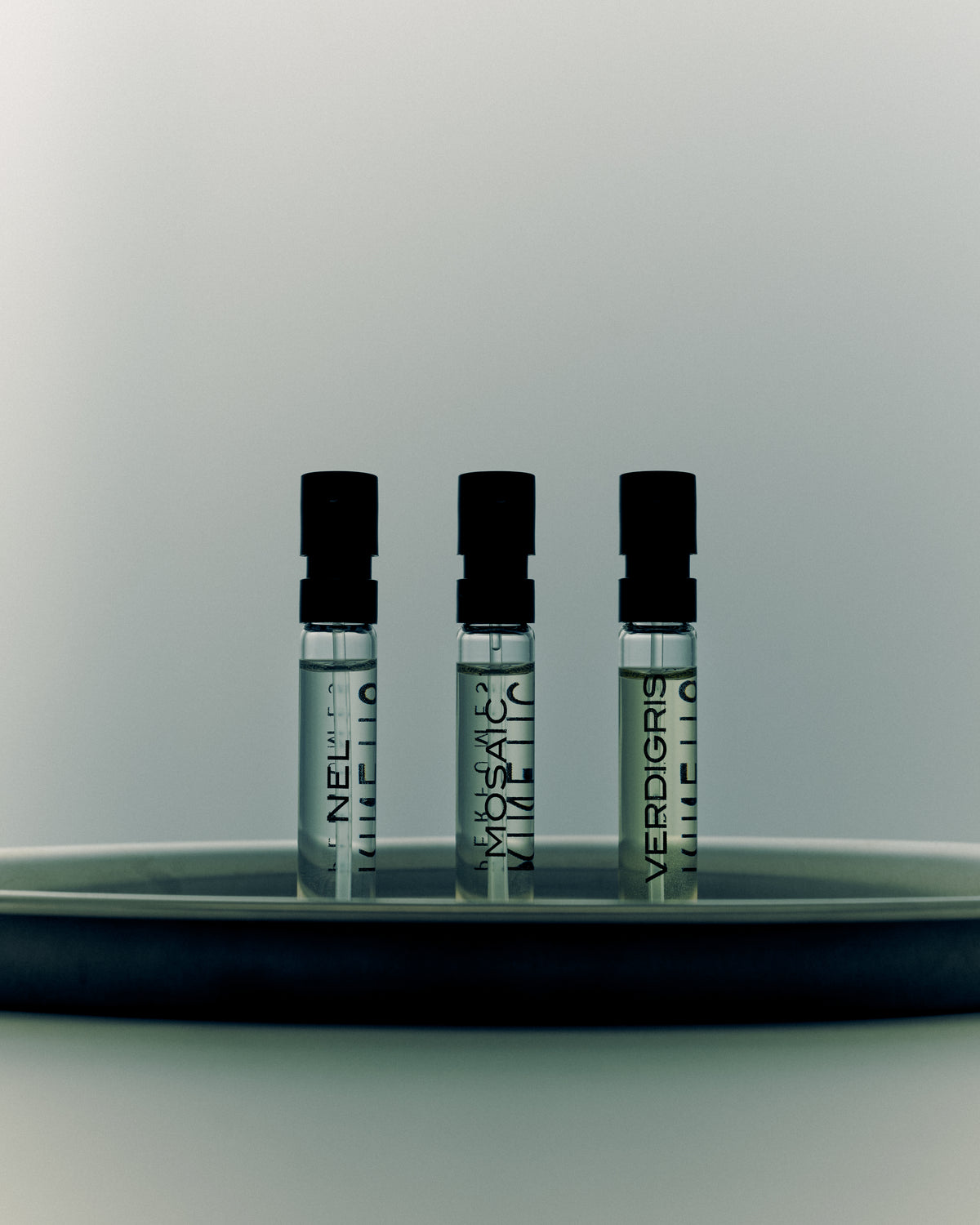 Drei Kinetic Perfumes Duftproben Nel, Mosaic und Verdigris auf grauem Tablett