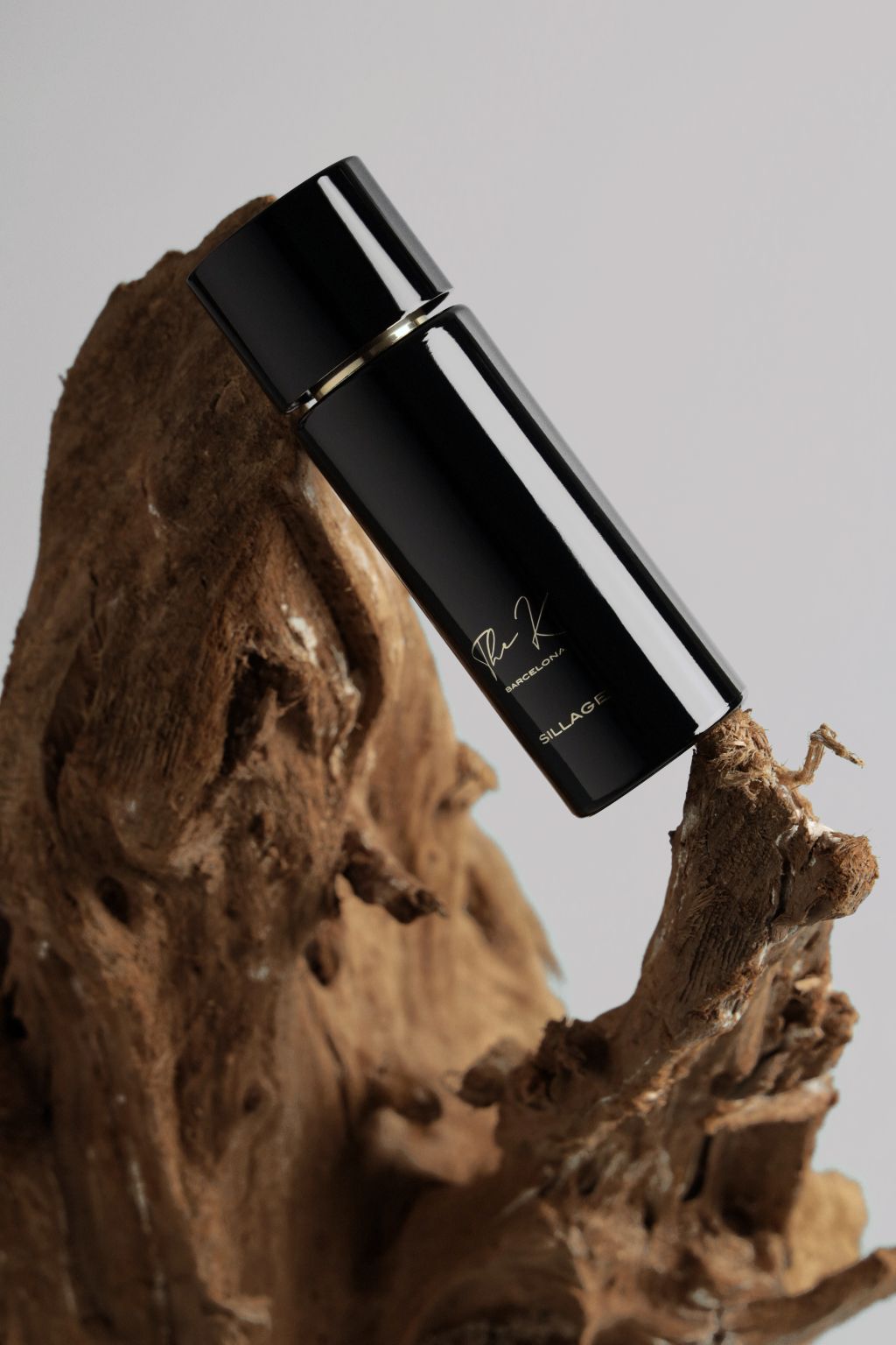 Kinetic Perfumes Sillage Extrait de Parfum 100 ml – schwarzer Flakon mit goldener Signatur auf Treibholz vor Hellgrau