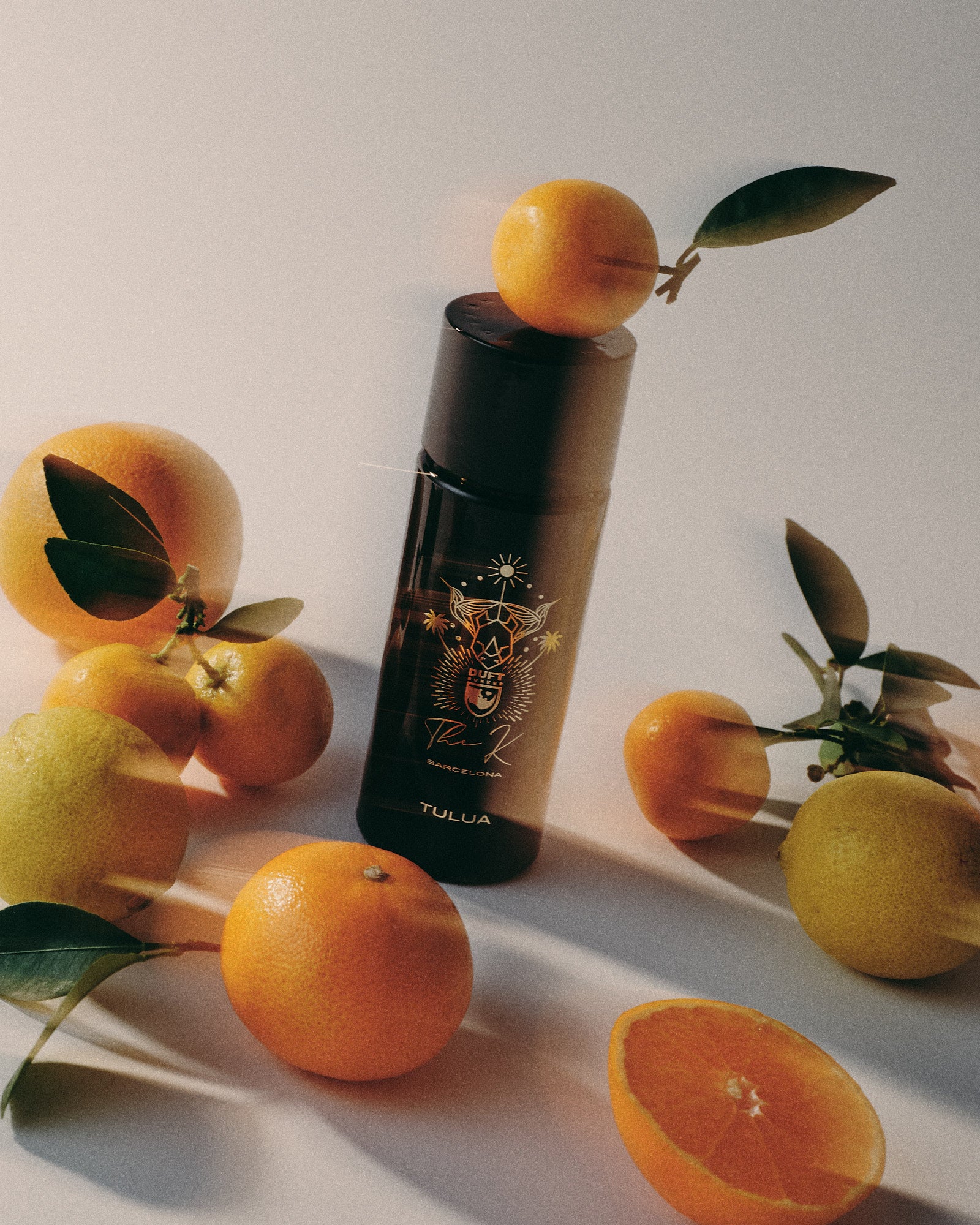 Kinetic Perfumes Tulua Flakon mit Goldmotiv zwischen Orangen und Zitronen