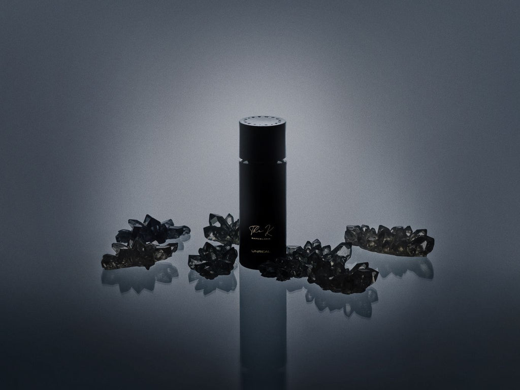 Kinetic Perfumes Unreal Extrait de Parfum 100 ml – schwarzer Flakon zwischen rauchgrauen Kristallen vor Dunkelgrau