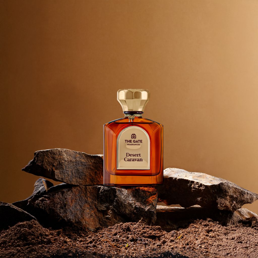 The Gate Desert Caravan Extrait de Parfum 100 ml – bernsteinfarbener Flakon auf Felsbrocken vor braunem Hintergrund