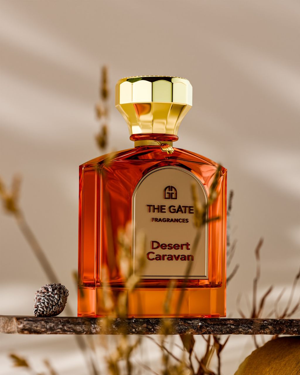 The Gate Desert Caravan Extrait de Parfum 100 ml – orangefarbener Flakon auf Holzbrett mit Trockengräsern und Kiefernzapfen