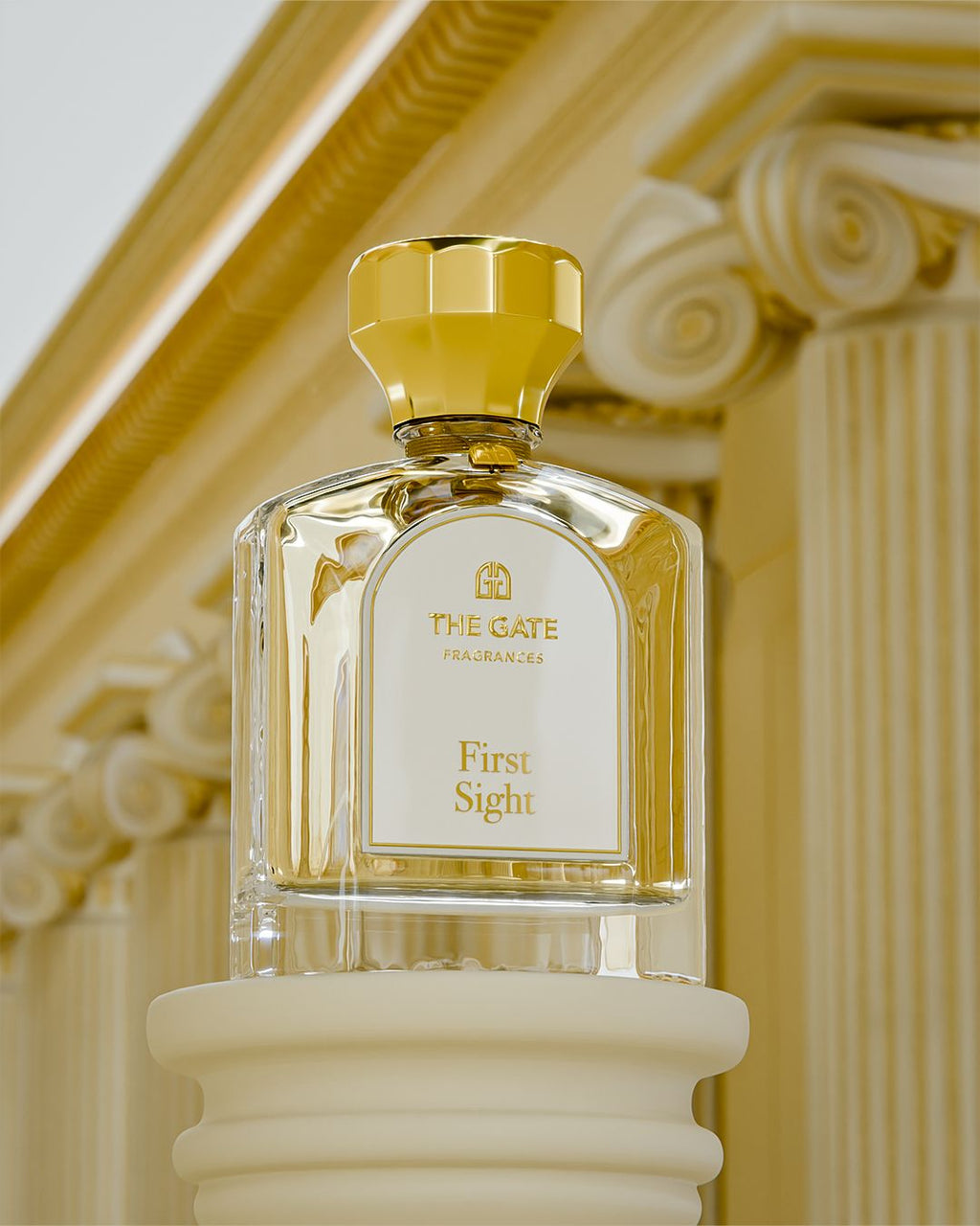 The Gate First Sight Extrait de Parfum 100 ml – hellgoldener Flakon auf Säule vor goldenen ionischen Kapitellen