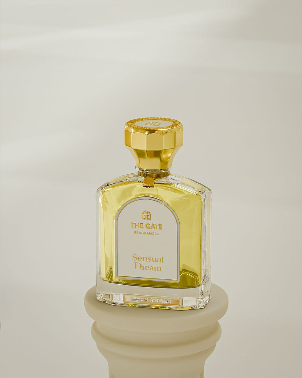 The Gate Sensual Dream Extrait de Parfum 100 ml – gelbgoldener Flakon auf cremefarbenem Sockel vor hellem Hintergrund