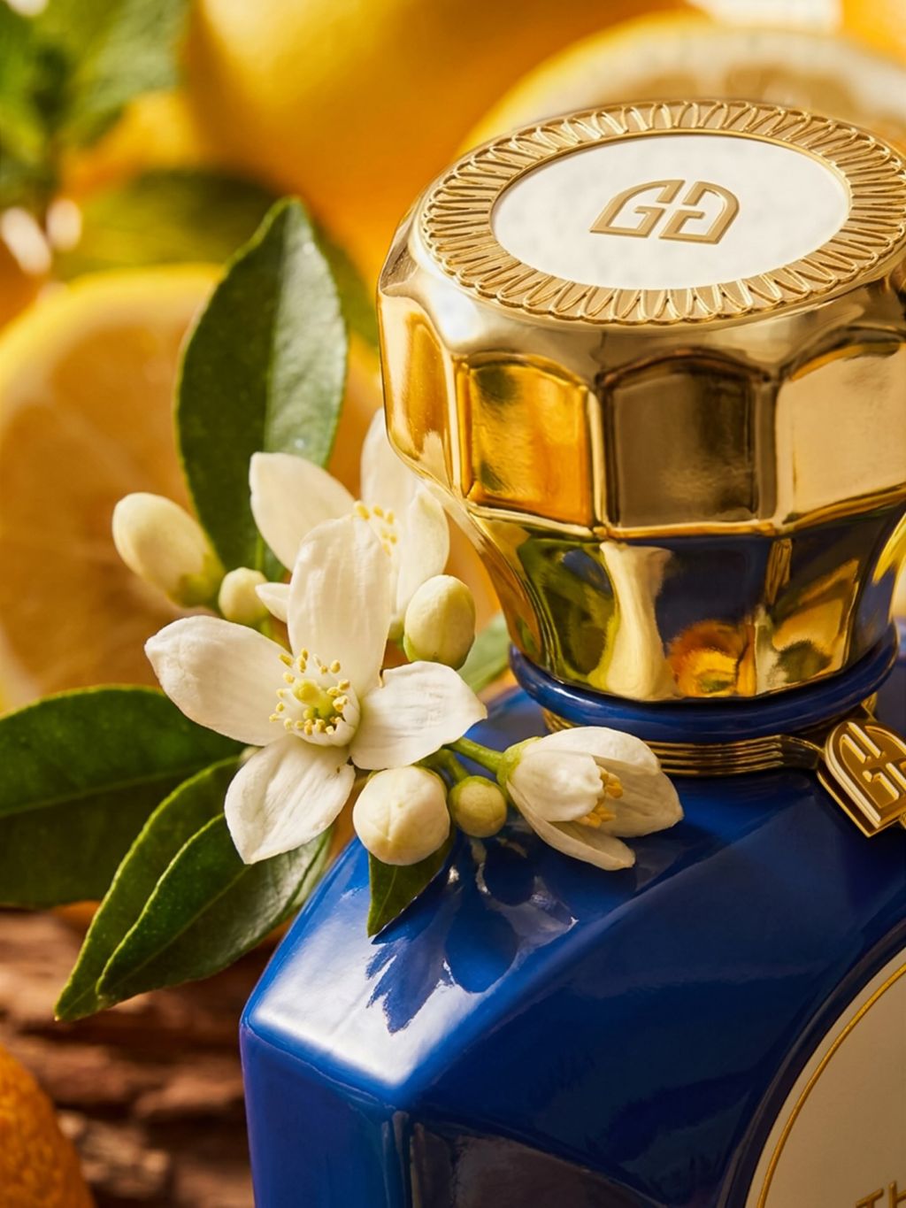 The Gate Sous Les Nuages Extrait de Parfum 100 ml – Nahaufnahme goldene Kappe mit Logo und Orangenblüten am blauen Flakon