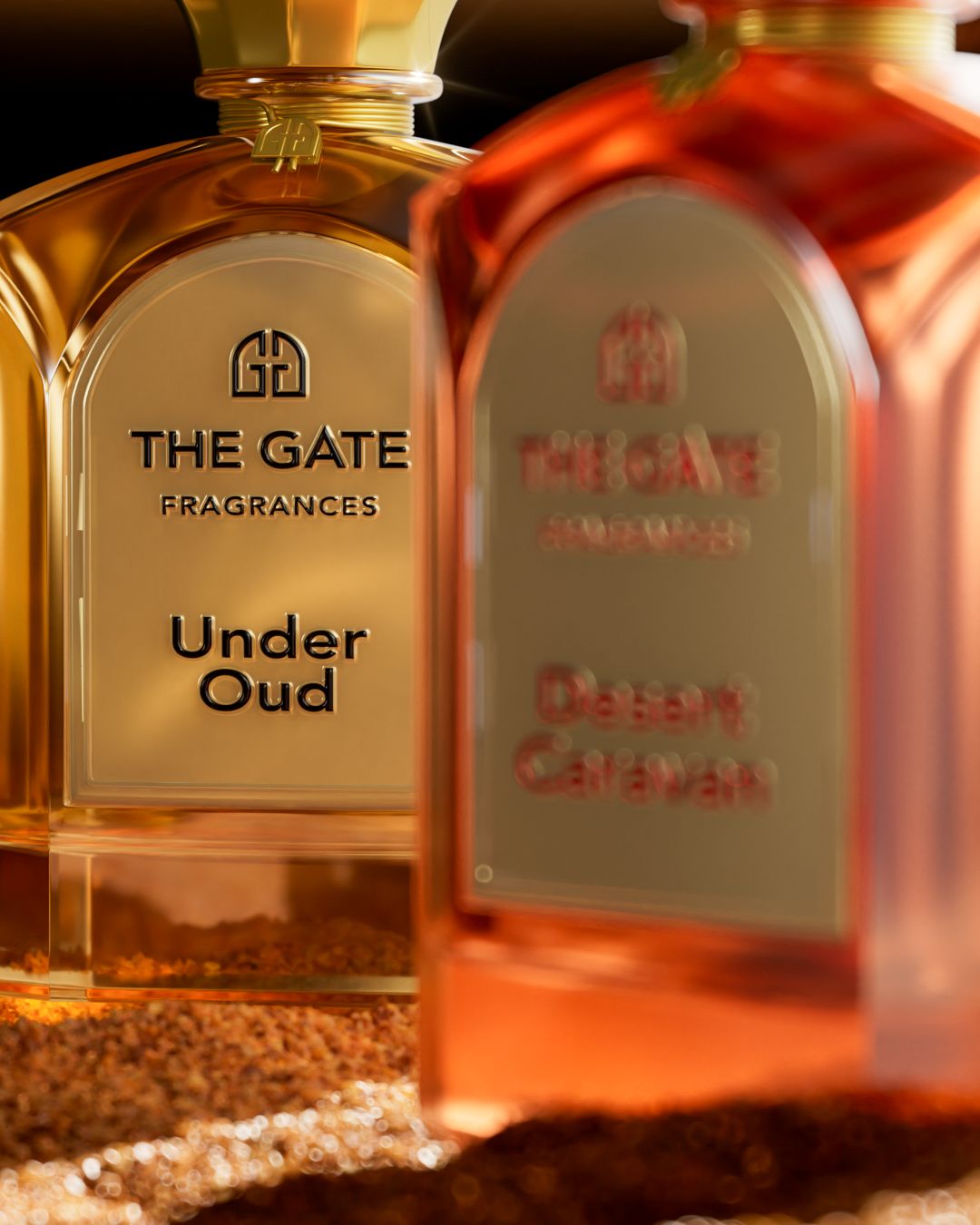 The Gate Under Oud Extrait de Parfum 100 ml – goldenes Etikett in Nahaufnahme, unscharfer orangefarbener Flakon im Vordergrund