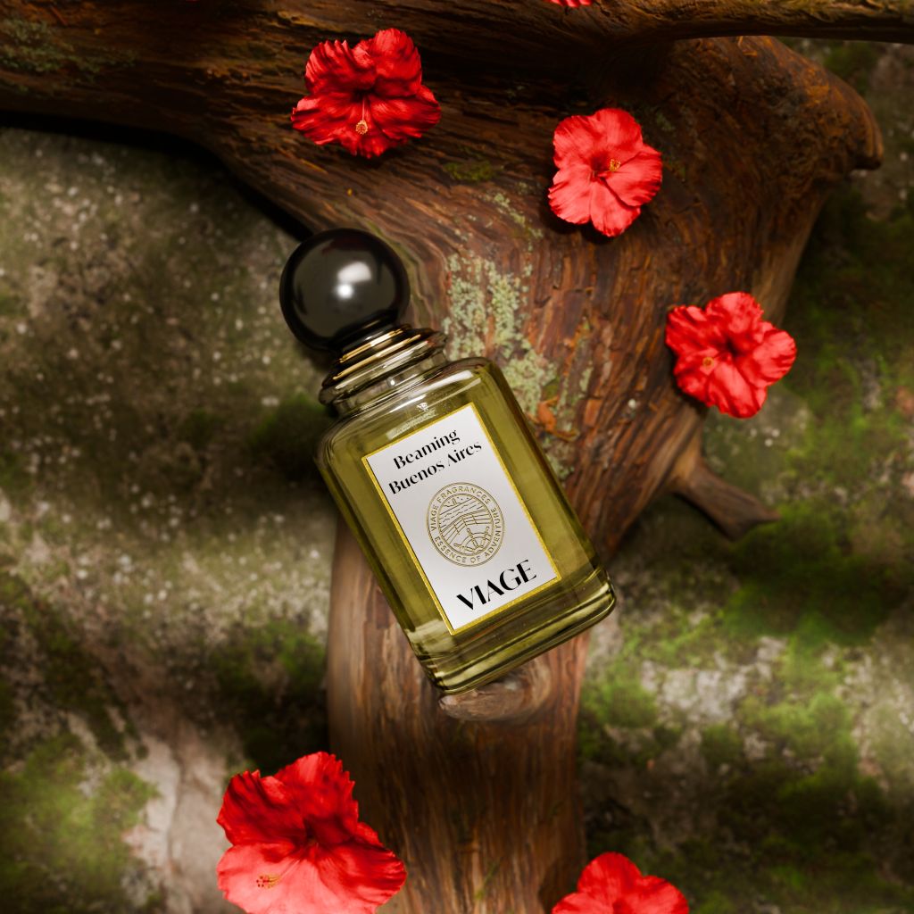 Viage Beaming Buenos Aires Extrait de Parfum 100 ml – Flakon schräg auf Baumstamm mit roten Hibiskusblüten und Moos, von oben