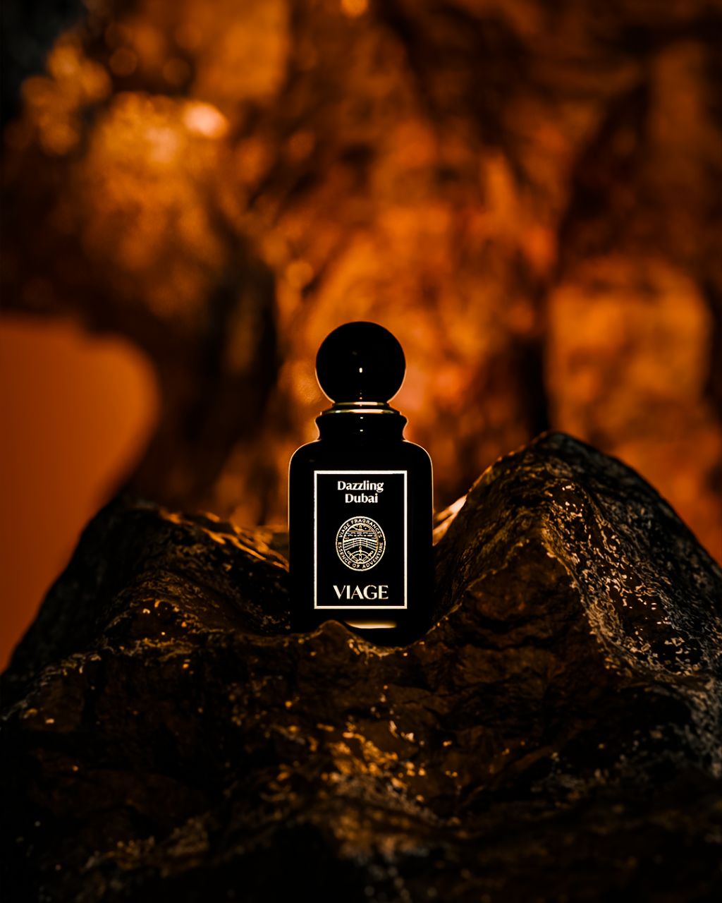 Viage Dazzling Dubai Extrait de Parfum 100 ml – Schwarzer Flakon auf dunklem Felsen vor orange leuchtendem Hintergrund