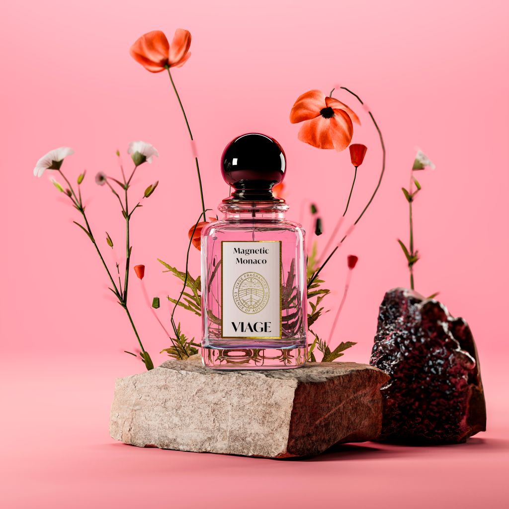 Viage Magnetic Monaco Extrait de Parfum 100 ml – Flakon mit rosa Inhalt auf Stein mit Mohnblumen vor rosa Hintergrund